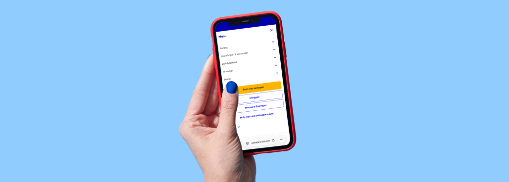 Eine Hand hält ein Mobiltelefon vor blauem Hintergrund