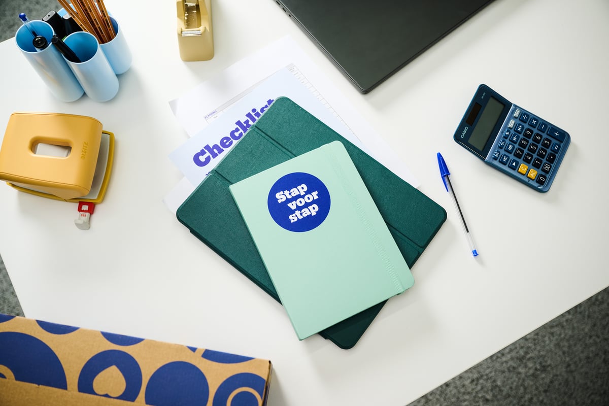 Tidy desk with a mint green notebook labeled 'Step by step', a checklist, a blue calculator, a pen, and office supplies.