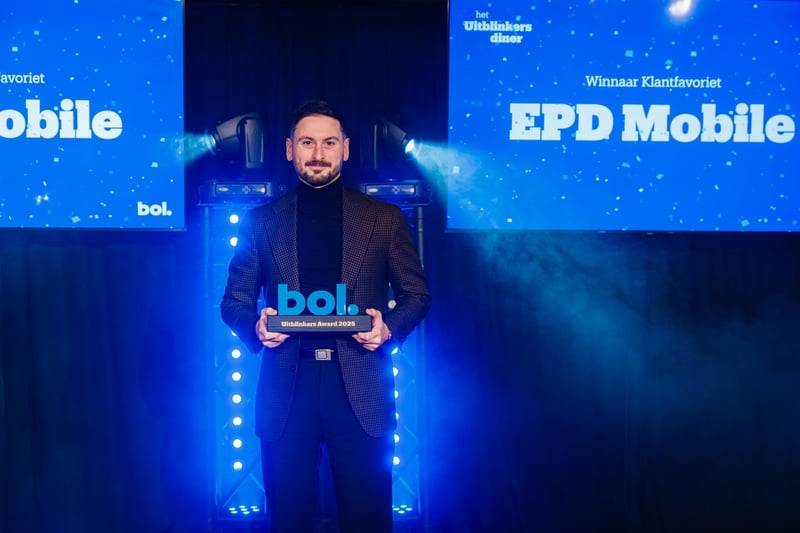 Man in a suit holds a blue award plaque with ‘bol. Achievers Award 2023’ on it. Blue lights and screens with ‘EPD Mobile’ create a festive atmosphere.