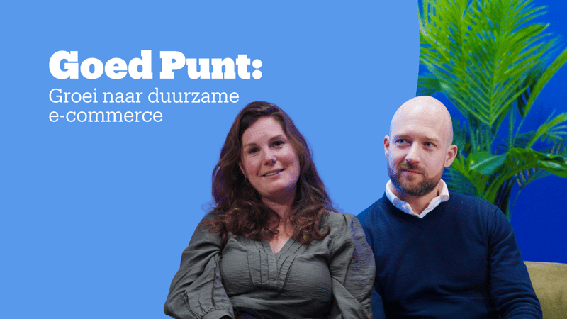 Twee mensen zitten voor een blauwe achtergrond met grote groene planten.