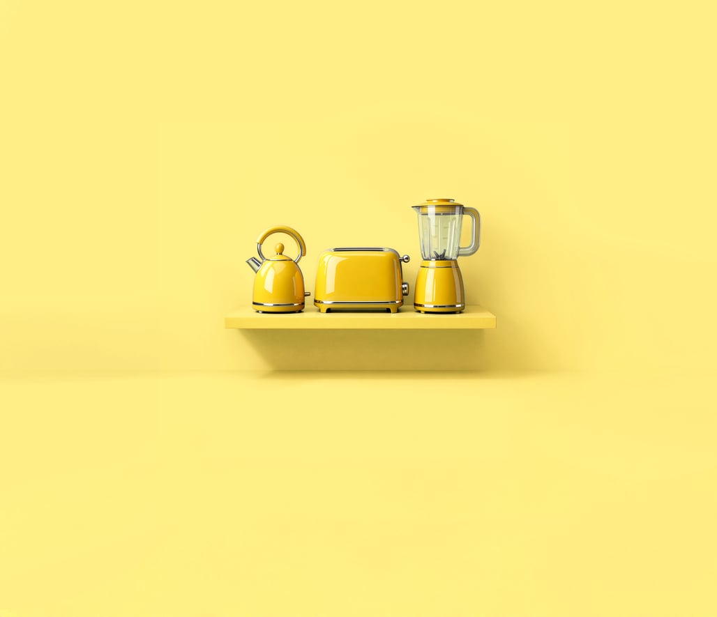 There are 3 kitchen appliance items on a yellow shelf against a yellow background