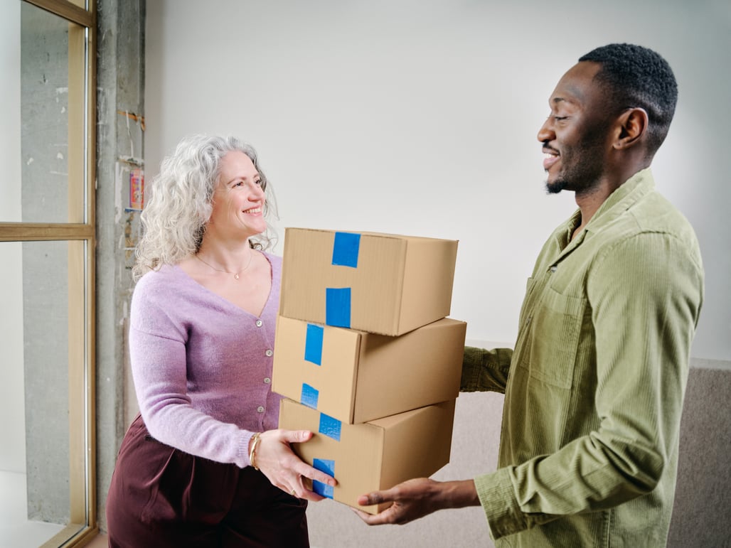 A lady is handed three parcels by a gentleman.