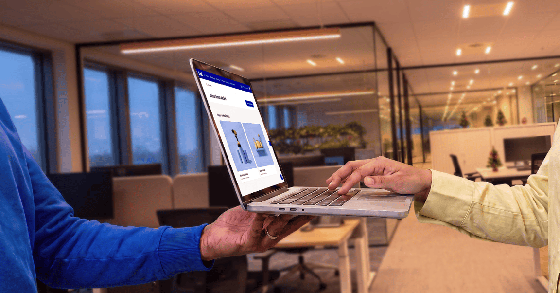 Hand holding laptop, other hand typing on the laptop