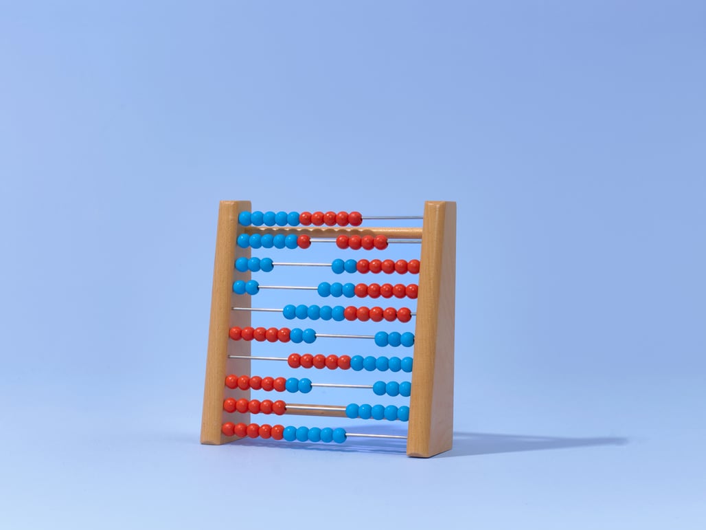 A wooden abacus with red and blue beads against a light blue background