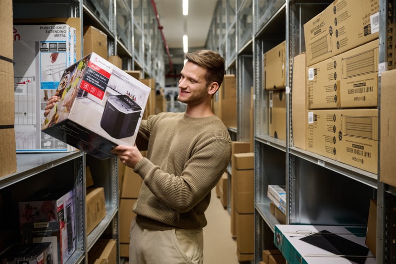 a person in a warehouse taking a box from the shelves