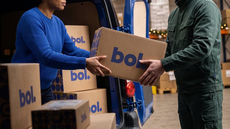 Deux employés d'entrepôt déchargent des cartons d'une camionnette de livraison.