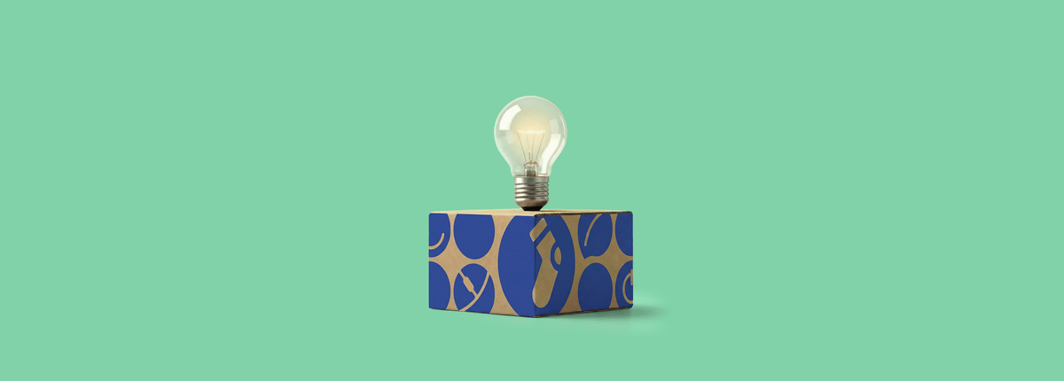 Een doos met een gloeilamp erboven, voor een groene achtergrond.
