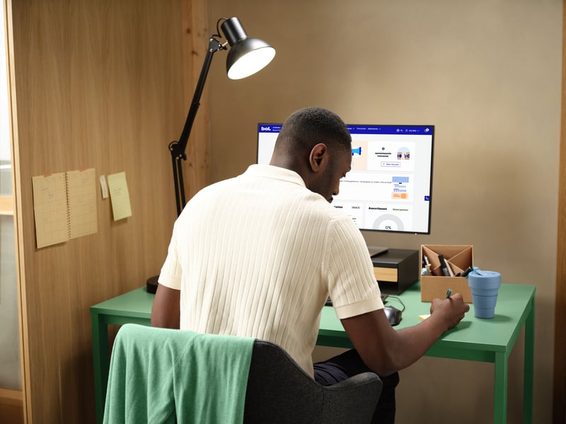 A man sits behind his laptop