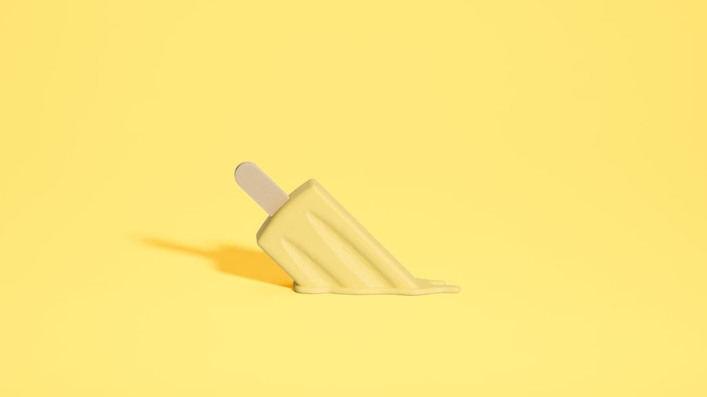 Une glace jaune en train de fondre sur un fond jaune.