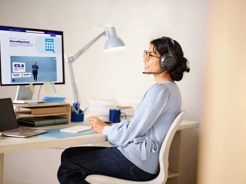a person with a headset behind a computer
