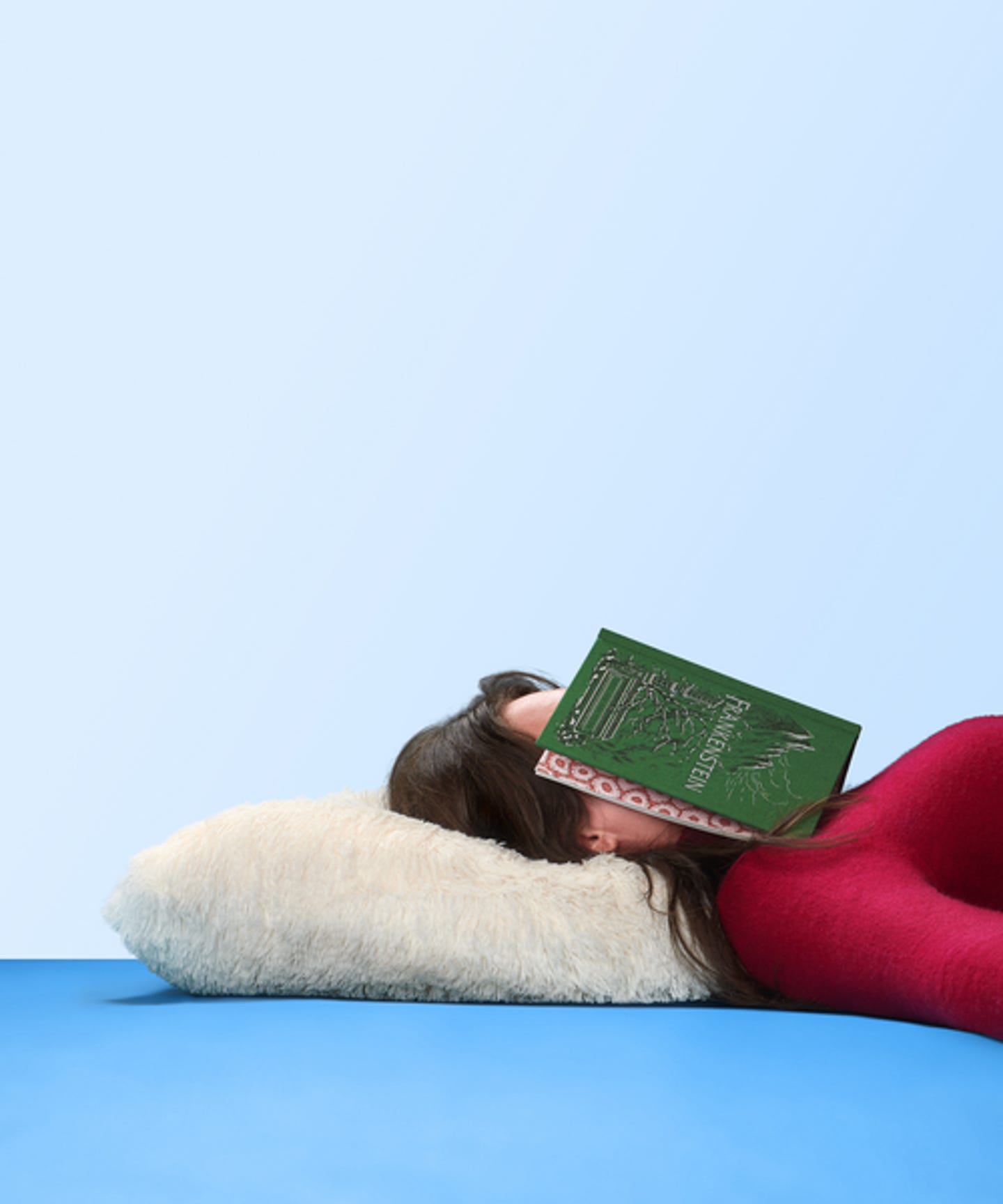 Vrouw op kussen met boek op hoofd