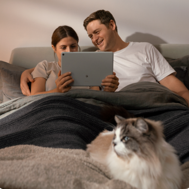 Een vrouw en een man die de Google Pixel Tablet in bed gebruiken-2.png