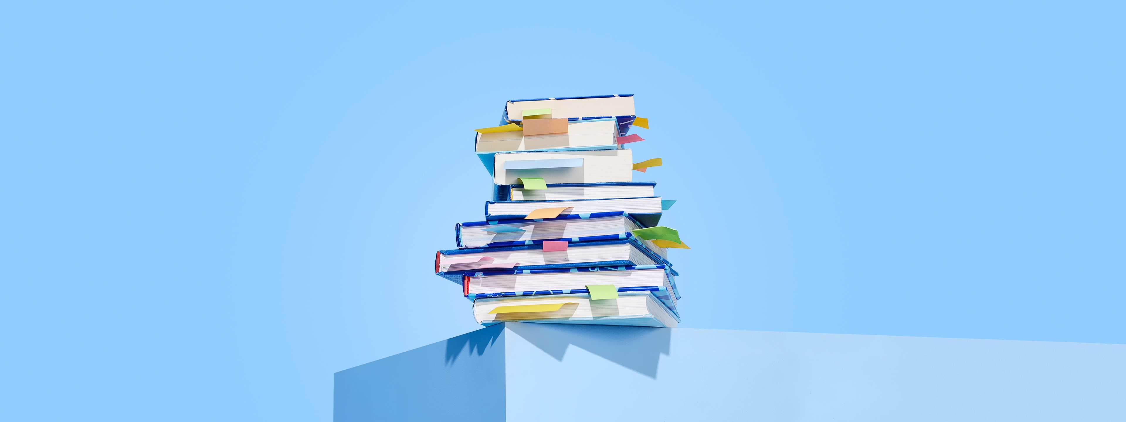 Persoon op boekenstapel met boek in hand